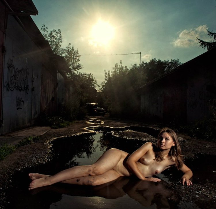 Naked woman in a dirty puddle